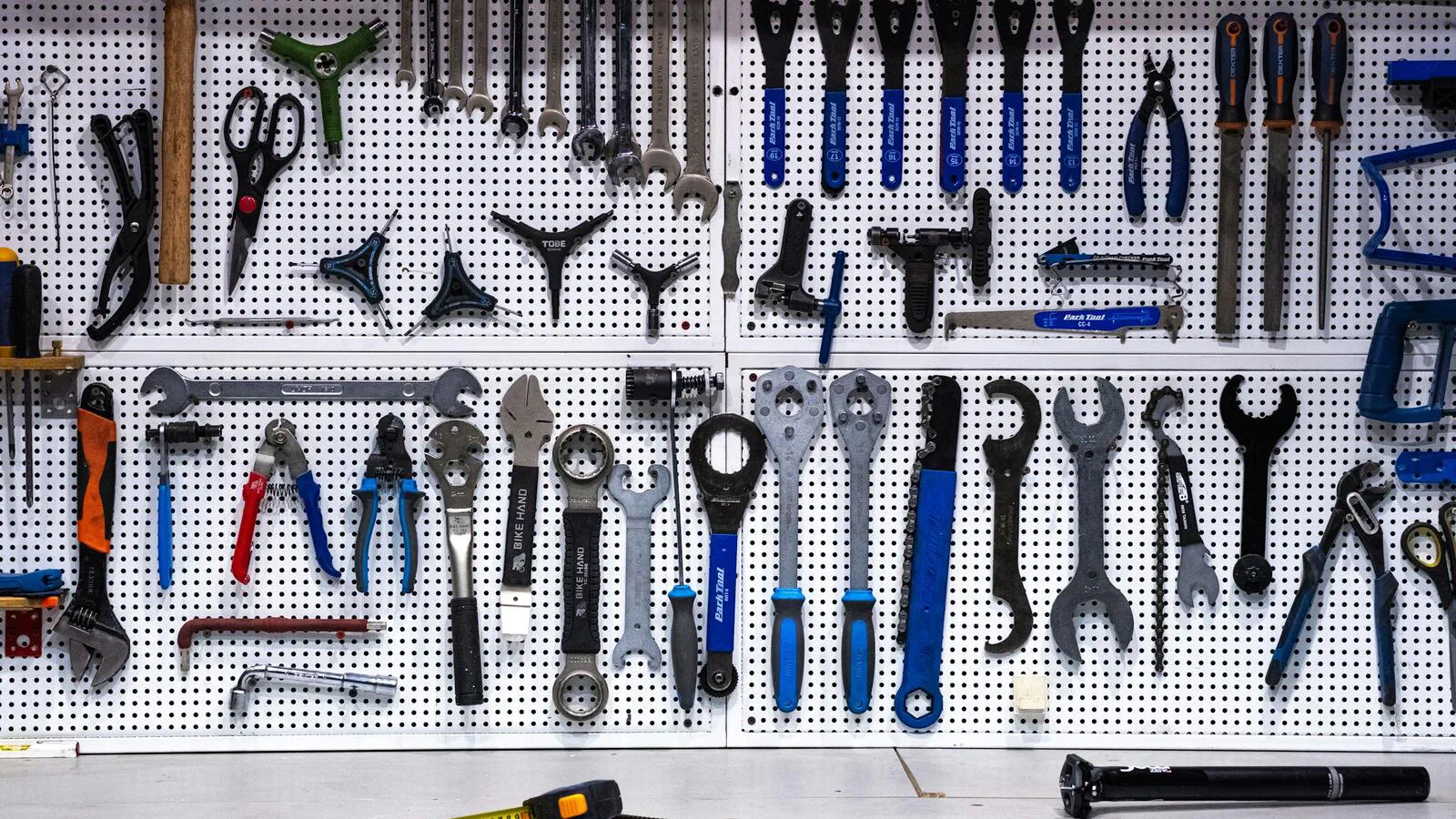 A pegboard wall of bicycle workshop tools, every wrench and plier hung in rows in full view